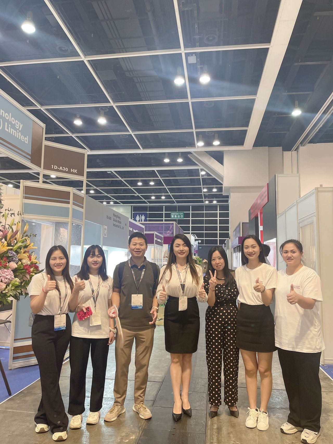 The Giant Watch team photographed at an exhibition, wearing visitor lanyards.