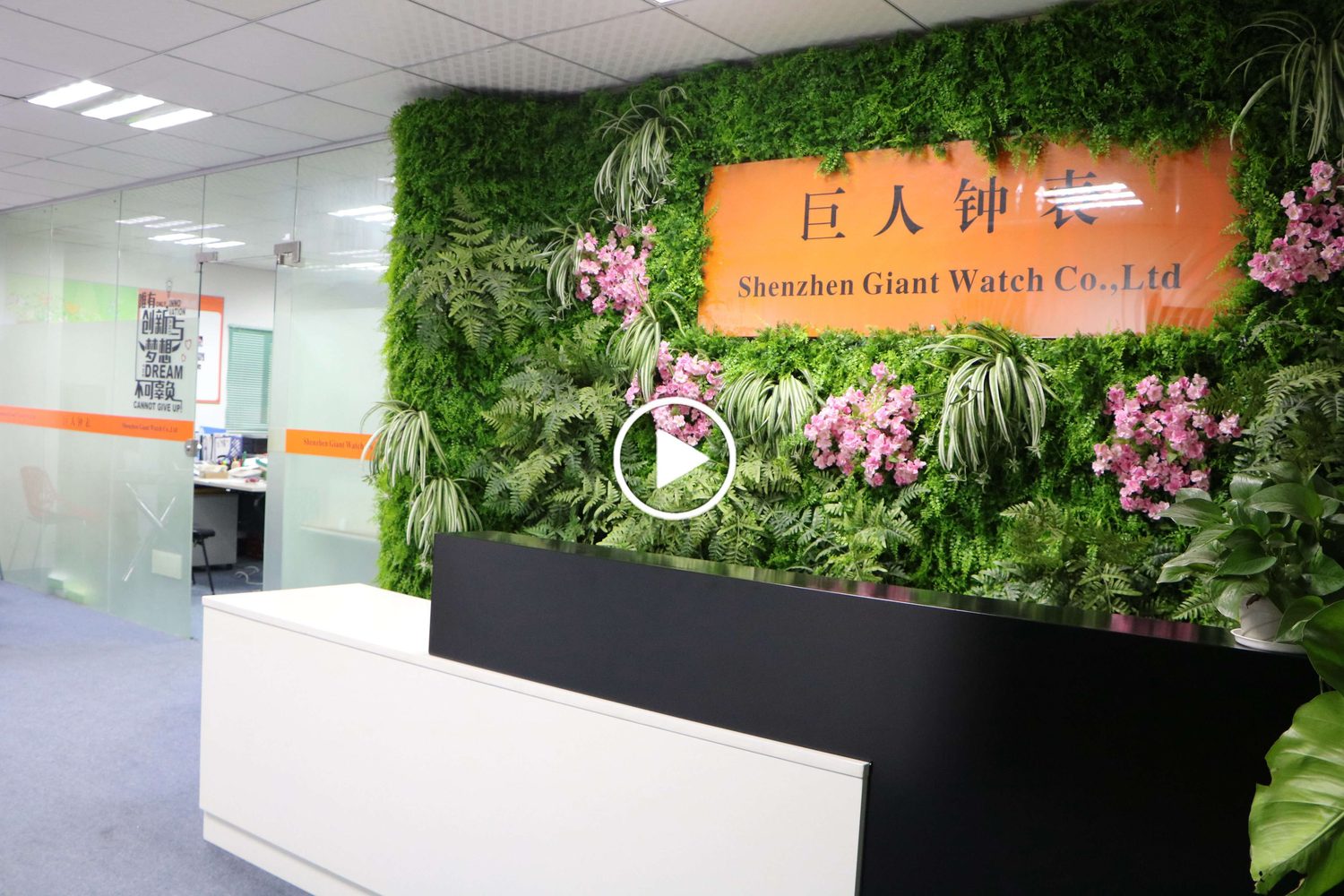 The reception counter at the Dalang Town plant, beside the planted wall carrying the company name board.